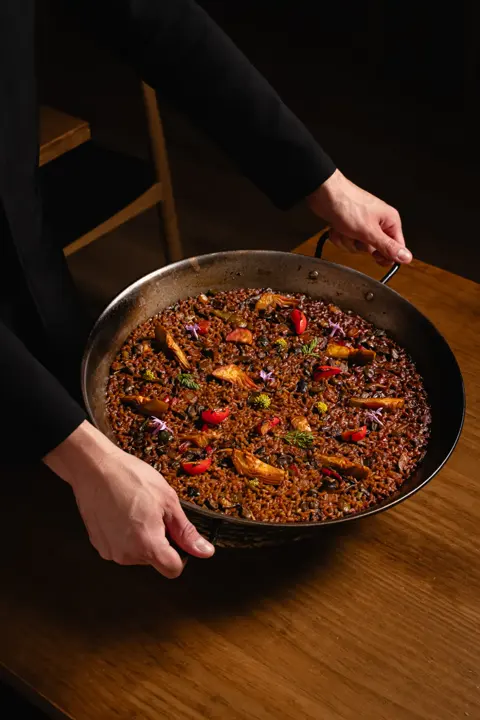 A la mesa. La paella llega entera