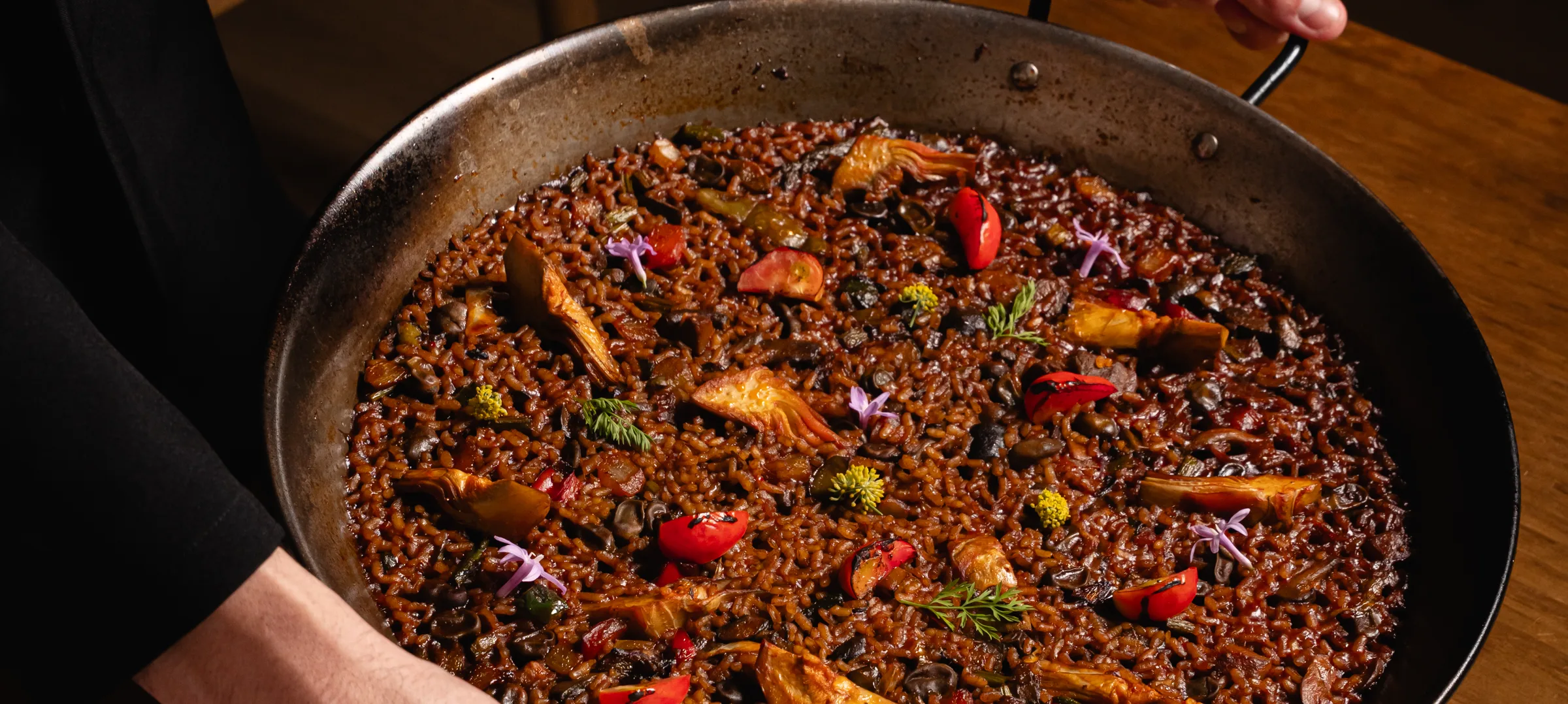 Paella de arroz llegando a la mesa
