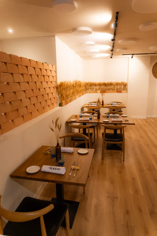 El comedor de La Rabiosa, con la pared de ladrillo y las espigas