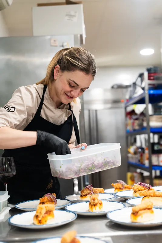 Cocineros y comensales en la cocina, al final del servicio