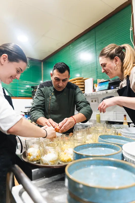 El equipo de cocina emplatando en fila para toda la mesa