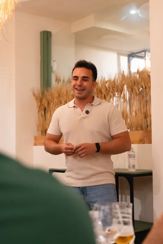 El bodeguero invitado presentando sus vinos de pie ante la mesa