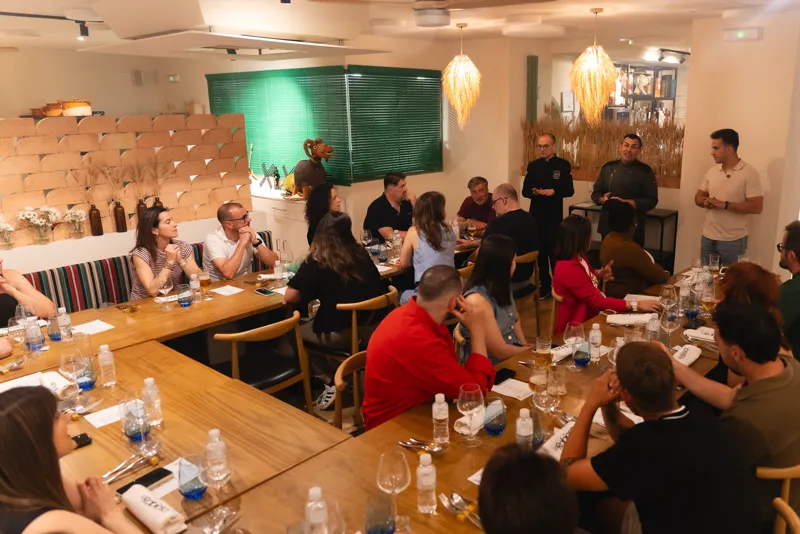 La sala entera sentada en una sola mesa larga